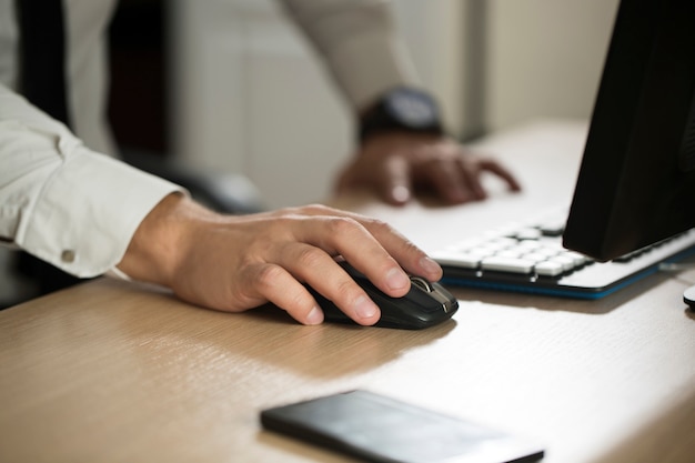 La mano del hombre de negocios utiliza el ratón de la computadora y escribiendo, formulario de acuerdo de asociación recortado para rellenar el primer plano. Éxito empresarial, contrato y documento importante, papeleo o concepto de abogado