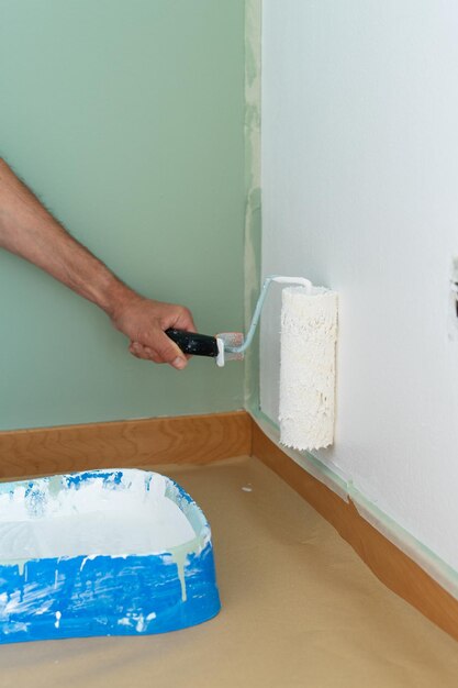 Foto mano de hombre pintando la pared blanca copiar espacio