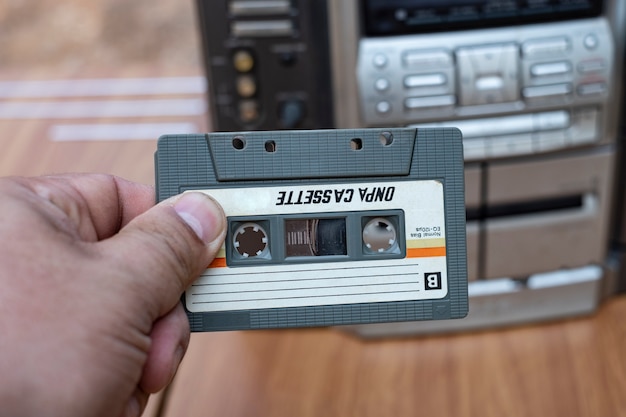 Mano de hombre poniendo cassette en el antiguo reproductor de cintas de audio