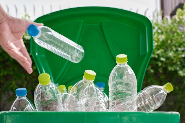 Mano de hombre poniendo reutilización de plástico para el concepto de reciclaje