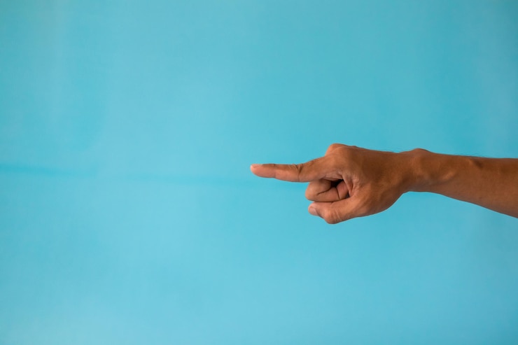 Foto la mano de un hombre con una postura o gesto que señala algo en un fondo azul