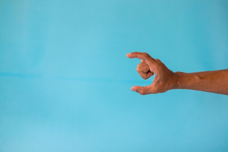 Foto la mano de un hombre con una postura o gesto de sostener o mostrar algo sobre un fondo azul