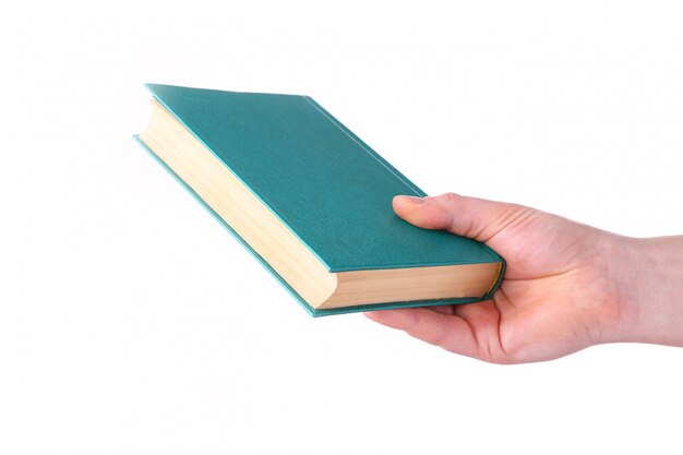 Mano del hombre que sostiene el libro viejo verde en el fondo blanco