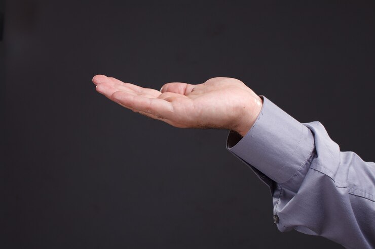 Foto mano de hombre sosteniendo algo aislado sobre un fondo oscuro
