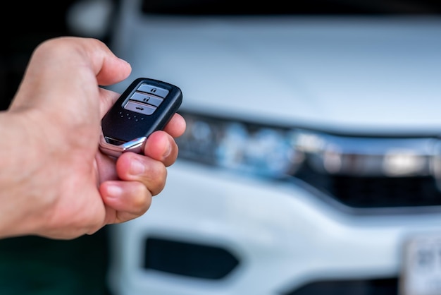 Mano de un hombre sosteniendo y empujando el control remoto del automóvil blanco, concepto de seguridad de transporte de tecnología