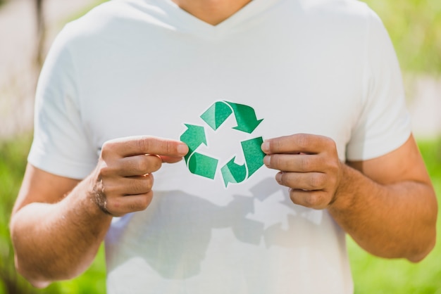 La mano de un hombre sosteniendo el icono de reciclaje