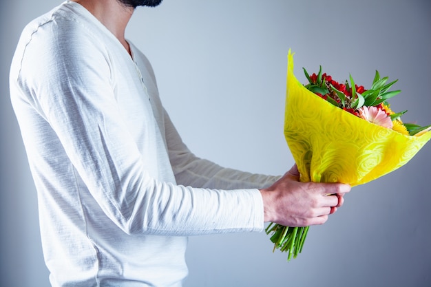 Mano de hombre sosteniendo ramo de flores