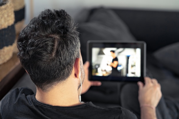 Mano de hombre sosteniendo usando tableta digital viendo la clase magistral en línea. aprender de forma remota.