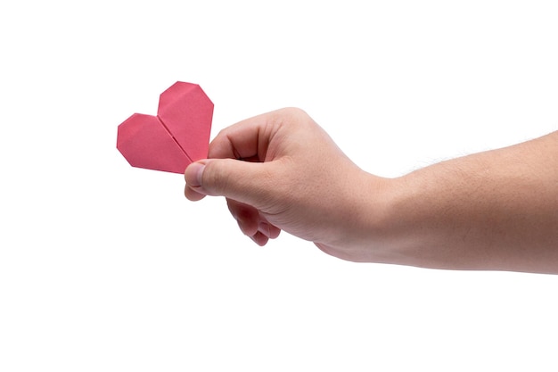 La mano de un hombre sostiene un corazón de papel aislado en un fondo blanco
