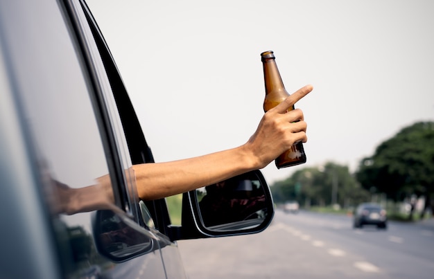 La mano de un hombre sostiene una jarra de alcohol.