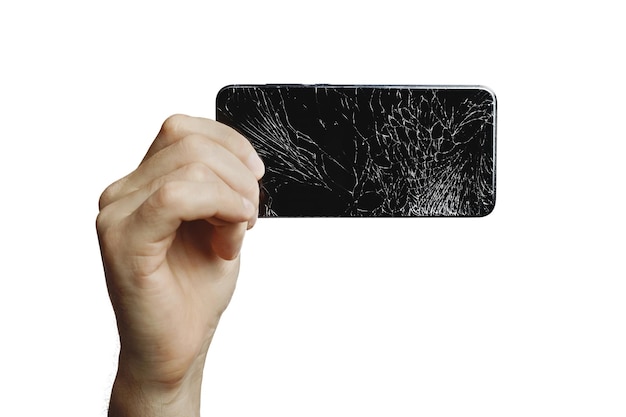 La mano de un hombre sostiene un teléfono negro con una pantalla rota aislado en un fondo blanco