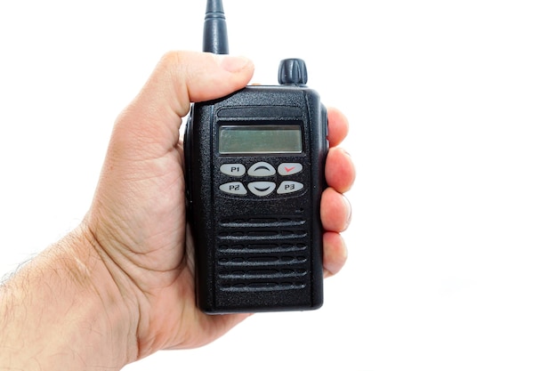 Foto la mano de un hombre sostiene un walkietalkie inalámbrico en un primer plano de fondo blanco