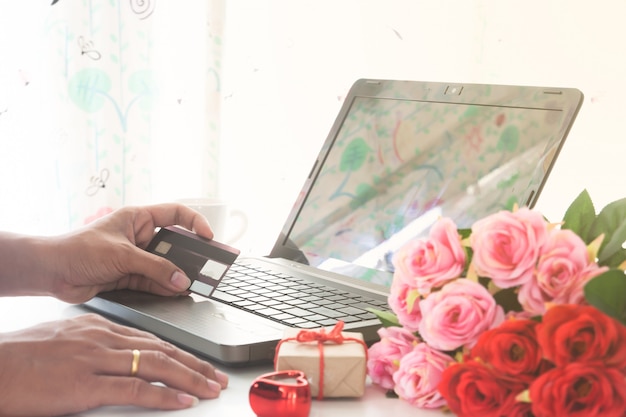 Mano de hombre con tarjeta de crédito y usando computadora