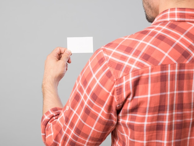 La mano del hombre con tarjeta de presentación en blanco