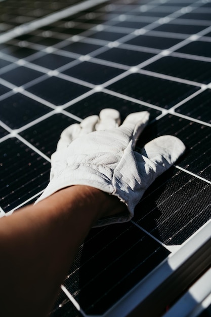 Foto la mano de un hombre técnico maduro tocando paneles solares en el techo de la casa para el autoconsumo de energía