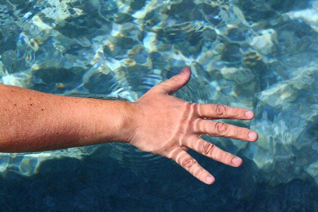 Foto la mano del hombre tocando el agua