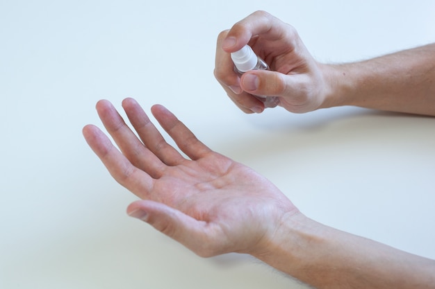 Mano de hombre usando dispensador de bomba de gel desinfectante para lavado de manos para protección coronavirus