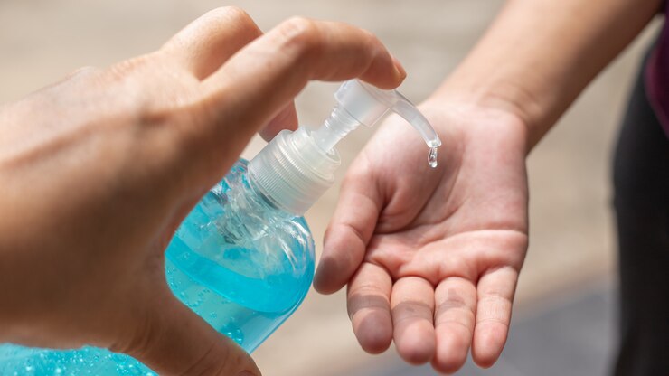 mano de hombre usando dispensador de gel desinfectante para lavado de manos, contra coronavirus novedoso o enfermedad de virus corona (Covid-19) en público interior