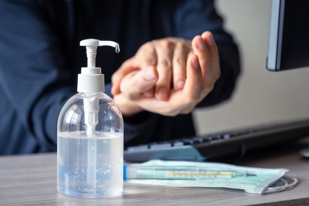 Foto mano del hombre usando gel desinfectante para germen limpio