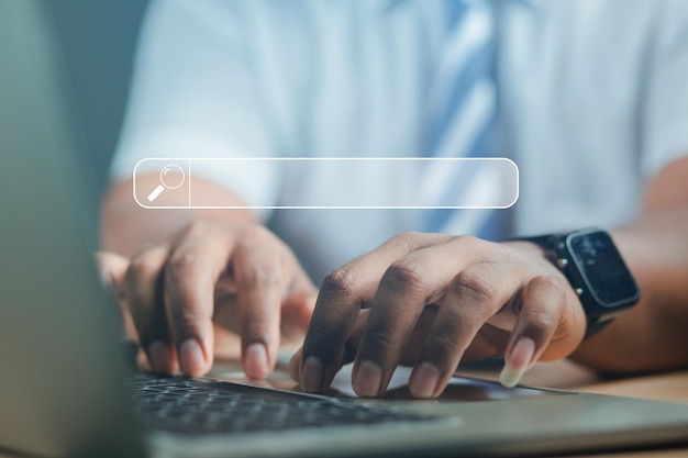 La mano del hombre usando el teclado de la computadora para buscar información usando la búsqueda en su sitio web