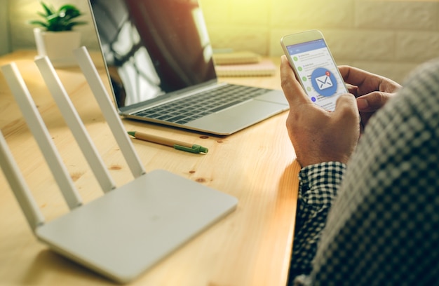 Foto mano de hombre usando teléfono móvil con aplicación de correo electrónico