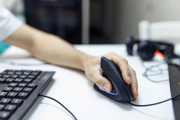 la mano del hombre utiliza un mousejoystick de computadora ergonómico vertical