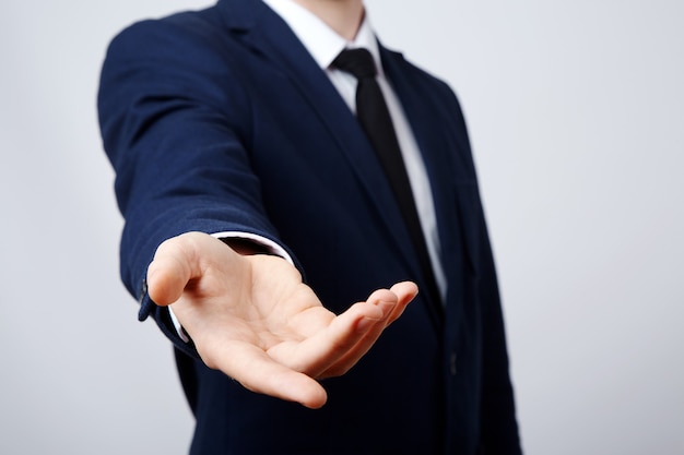 Mano de hombre vistiendo traje mostrando una pared de letreros, de cerca, concepto de negocio, gestos, invitando, mano amiga.