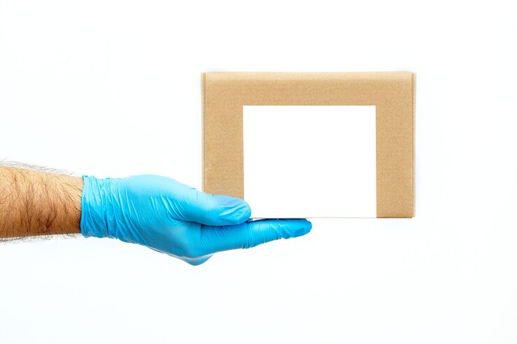 Mano de hombres sosteniendo cajas de cartón en guantes médicos. copie el espacio. Transporte de entrega rápido y gratuito. Compras online y entrega Express.