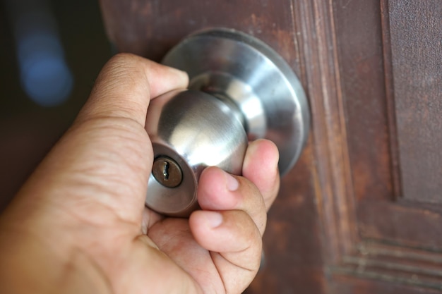 Foto mano humana está abriendo la puerta de la habitación