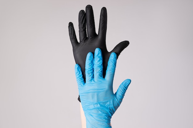 Mano humana con guantes de látex en pared gris, brote de enfermedad por coronavirus 2019 o covid-19