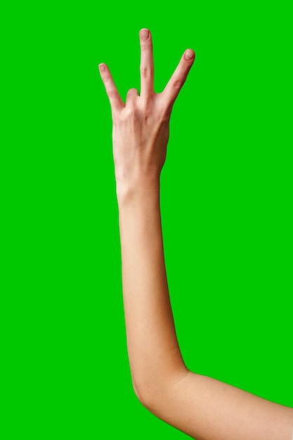 La mano humana muestra el número tres contra un fondo verde sólido