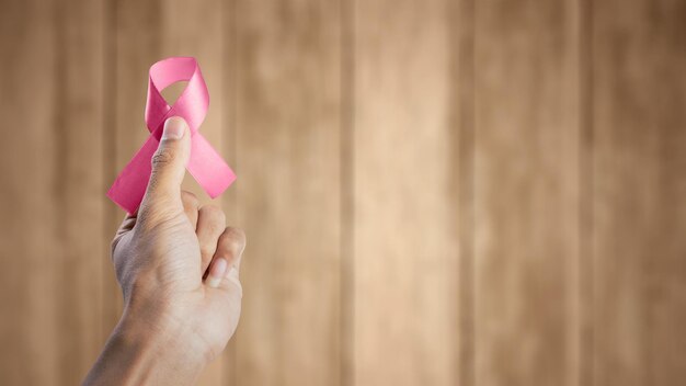 Mano humana que muestra una cinta rosa de concienciación Concepto de concienciación sobre el cáncer de mama