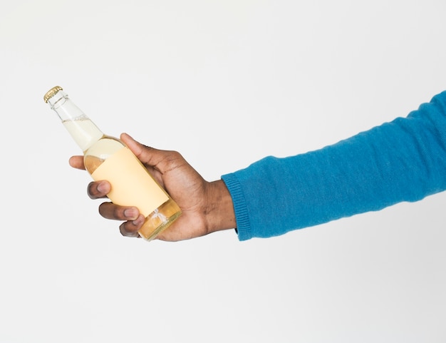 La mano humana sosteniendo la botella bebe concepto