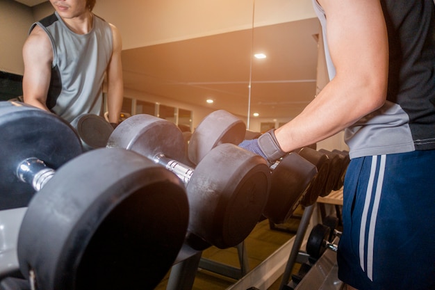 Mano humana sosteniendo pesas en el gimnasio