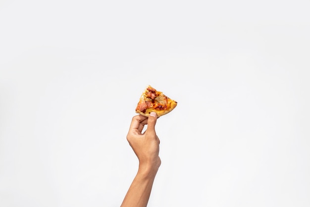 Foto una mano humana sosteniendo una rebanada de pizza con un fondo blanco