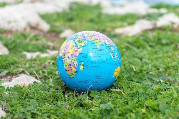 La mano humana sostiene un pequeño globo frente al mar.