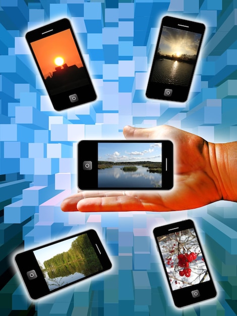Foto mano humana con teléfonos modernos en un fondo azul abstracto