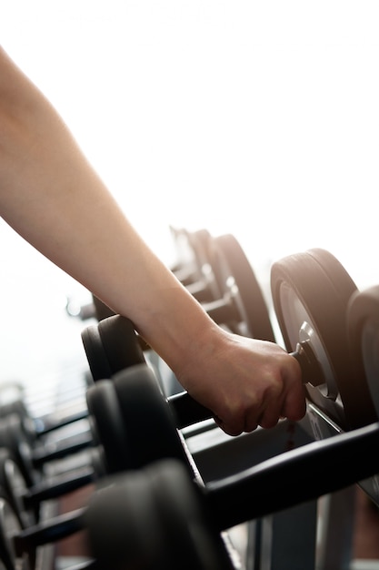 Mano humana, tomando pesas en el gimnasio