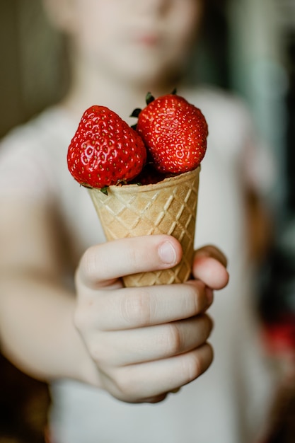 Mano infantil con fresas orgánicas