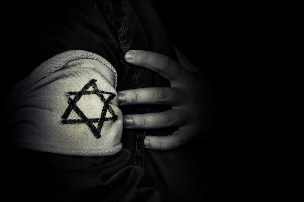 Mano con la insignia de la estrella de David El concepto del Holocausto estilizado en la década de 1940 La memoria de las víctimas del Holocausto foto retro en blanco y negro