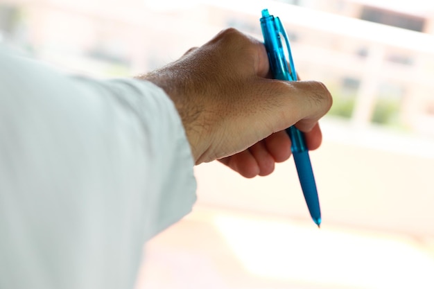 Una mano izquierda escribiendo con un bolígrafo en un cuaderno para el día internacional de los zurdos.