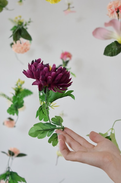 La mano de una joven con fondo de flores con flores bokeh