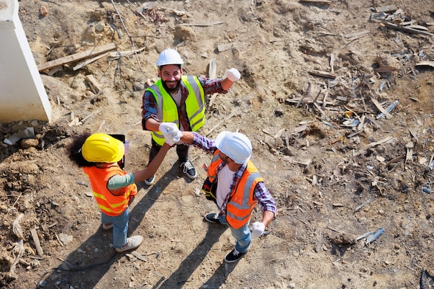 Mano junta vista superior Unidad de trabajo en equipo exitosa Ingeniero mecánico y equipo de construcción en el sitio de construcción del proyecto de la casa Manos reunidas