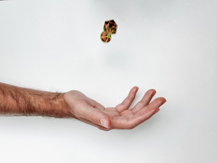 Foto la mano lanzando dados coloridos contra un fondo blanco capturando el movimiento