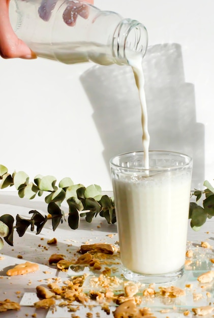 La mano llenando un vaso de leche