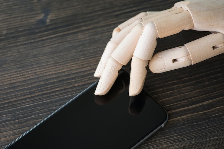 Foto mano de madera artificial con teléfono moderno en tablero de madera