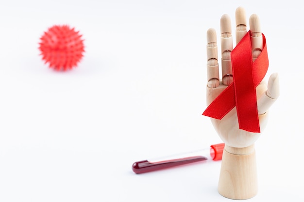 Mano de madera de un maniquí con una cinta roja