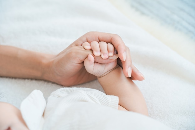 La mano de la madre sosteniendo la mano de su bebé