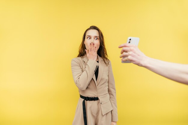 La mano de Man39s muestra un teléfono inteligente a una mujer que se tapa la boca en estado de shock y mira la pantalla