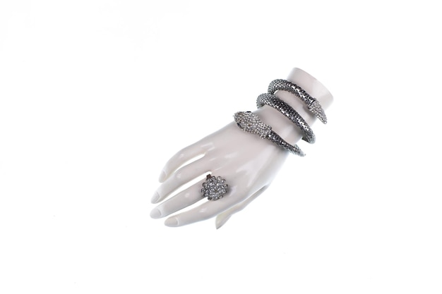 Foto mano de maniquí con brazalete de joyería aislado sobre fondo blanco.